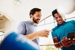 photo of two happy men looking at a smartphone together