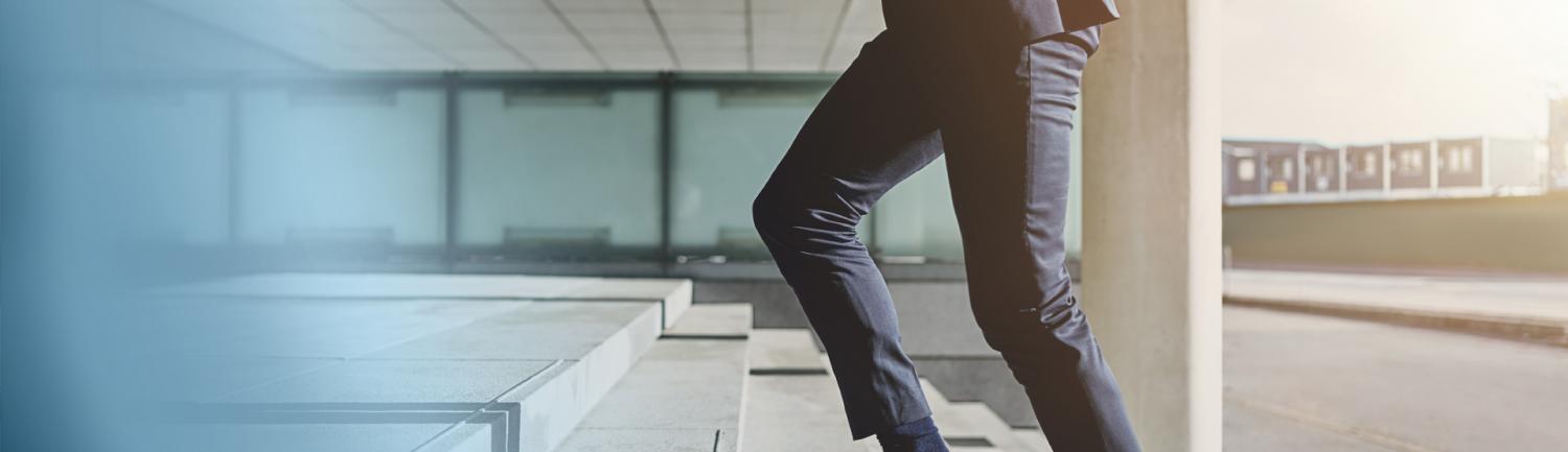 The legs of a man walking up the stairs